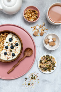 Bowl of muesli and blueberries on yogurt, assortment of seeds, brown and white sugar cubes Bowl of muesli and blueberries on yogurt, assortment of seeds, brown and white sugar cubes
